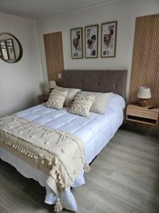 un dormitorio con una cama grande en una habitación en Depto Mirador del Fiordo, en Puerto Natales 14 fotos más