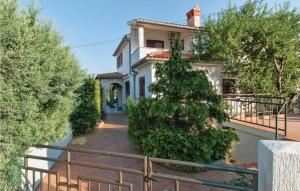 a white house with trees in front of it at Holiday Home Krse Cr in Premantura