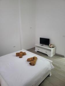 ein Schlafzimmer mit einem weißen Bett mit Handtüchern darauf in der Unterkunft Guest House Eleni in Balş