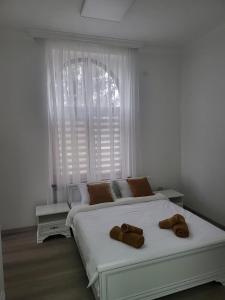 ein Schlafzimmer mit einem Bett, auf dem zwei braune Handtücher liegen in der Unterkunft Guest House Eleni in Balş