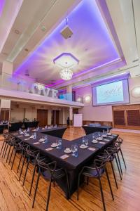 een grote vergaderruimte met een lange tafel voor een scherm bij Hotel Agit Congress&Spa in Lublin