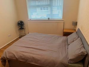 an empty bed in a room with a window at Kenlouis in Northfleet