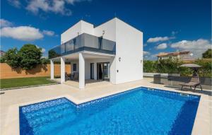 a villa with a swimming pool in front of a house at Villa Lumalu in Orbanići