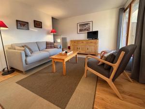 a living room with a couch and a table at Appartement cosy pour 4 avec WiFi proche pistes et commerces - FR-1-733-93 in Crest-Voland