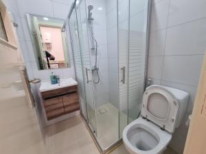 a bathroom with a toilet and a glass shower at Downtown Living Boutique Apartments in Amman +74 photos