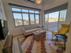 a living room with a couch and chairs and windows at Downtown Living Boutique Apartments in Amman