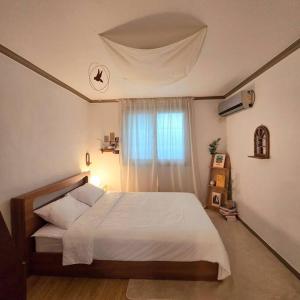 a bedroom with a large bed with a window at Stay Dongdaegu in Daegu