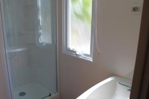 a bathroom with a shower and a tub and a window at Camping Tucan - Mobile Homes by Lifestyle Holidays in Lloret de Mar