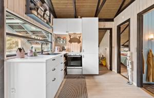 a kitchen with white cabinets and a large window at Stunning Home In Rønde With Wifi in Rønde