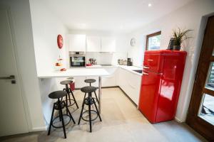 a kitchen with a red refrigerator and bar stools at Ferienwohnung Hanhofen in Hanhofen