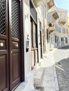 un vicolo con una porta marrone su una strada di Lithos Syros a Ermoupoli