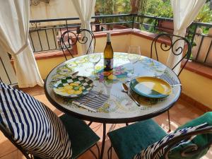 a table with a bottle of wine and glasses on a balcony at Case Borgo Vacanze in Letojanni