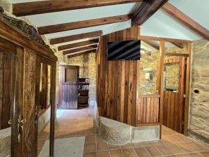 a living room with wooden walls and a tv on a wall at Campomuiños in A Pobra do Caramiñal