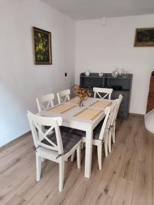 a white dining room table with white chairs at Apartament pod Wieżą Srebrna Góra in Srebrna Góra