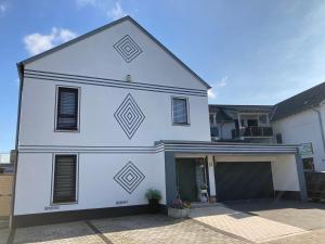 a white building with a garage in a driveway at Ferienwohnungen Bali in Rust