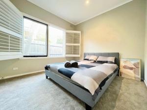 a bedroom with a large bed and a large window at Villa pool garden in Melbourne