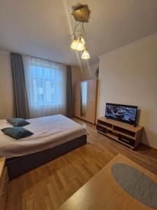 a bedroom with a bed and a flat screen tv at Lāčplēša Central Apartments in Riga