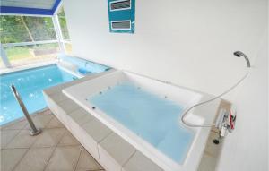 a swimming pool with a tub in a bathroom at Awesome Home In Ebeltoft With Sauna in Ebeltoft