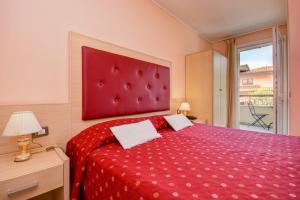 a bedroom with a red bed with a red headboard at Camere America B&B in Sirmione