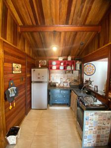 瓜拉雷马Cabana com Jacuzzi em Guararema的厨房设有木墙、冰箱和橱柜。