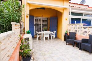 a patio with a table and chairs on a house at l'Azur 4 Pers Clim Parking Accès plage direct in Le Barcarès