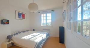 a bedroom with a bed and two windows at Villa Anamour in Draguignan