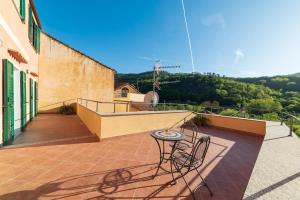 a patio with a table and chairs on a balcony at Ca du Muccin in Calice Ligure