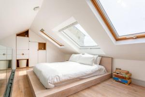 a bedroom with a white bed and a skylight at North Laine Townhouse with Jacuzzi Hot Tub in Brighton & Hove