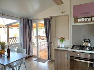 a kitchen and dining room with a table and a view of a patio at Camping Tucan - Mobile Homes by Lifestyle Holidays in Lloret de Mar