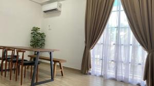 a dining room with a table and a window at Pearl Castlestay in Tanjung Karang