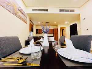 Una mesa de comedor con platos y vasos encima. en Aspire Tower -Two Bedroom Urban Getaway, en Manama