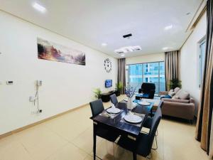 Una sala de estar con una mesa de comedor y un sofá. en Aspire Tower -Two Bedroom Urban Getaway, en Manama
