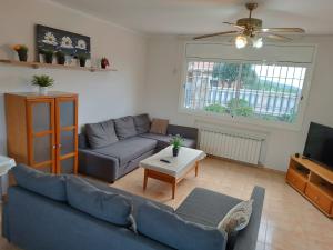 een woonkamer met een blauwe bank en een tv bij Villa Galicia in Lloret de Mar