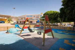a playground with slides and swings in a park at Home2Book Cozy Beachfront Getaway in Tarajalejo in Tarajalejo
