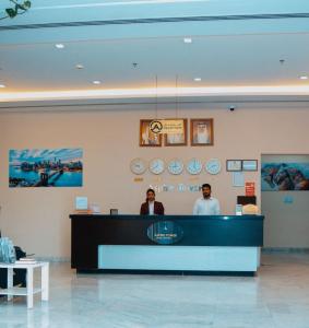 two people standing at the counter of a hair salon at Aspire Tower - Plush One Bedroom Juffair in Manama