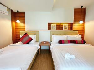 zwei Betten in einem Zimmer mit weißen Laken in der Unterkunft CozyHouse near MRT QSCC Convention Center 4BR 10ppl in Bangkok