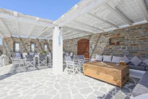 un padiglione con un divano, sedie e un tavolo di Galani, Immaculate Home with Private Pool & Beach View in Kastraki, Naxos a Kastraki
