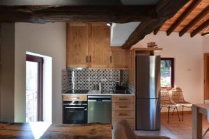 a kitchen with wooden cabinets and a stainless steel refrigerator at Feel Discovery Casa da Pedra in Arouca