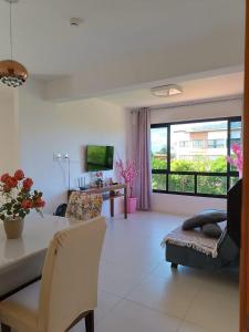 un soggiorno con un tavolo e un divano di Apartamento em Guarajuba - Condomínio Paraíso dos Coqueiro a Guarajuba