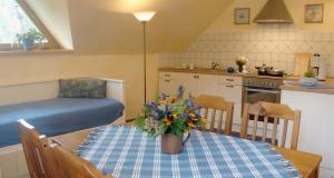 a kitchen and dining room with a table with flowers on it at Malinowa Chata in Szczyrk