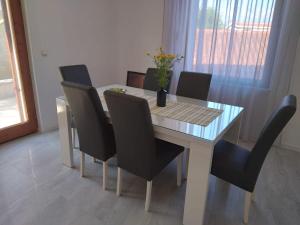 a dining room table with black chairs and a table with a glass top at Apartments and Rooms Ref in Sumartin