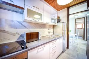 a kitchen with white cabinets and a sink at Apartments and Rooms Ref in Sumartin