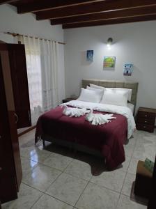 une chambre avec un grand lit avec des oreillers blancs dans l'établissement Pousada Bonamigos, à Santa Teresa