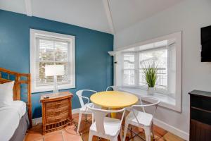 a bedroom with a table and chairs and a bed at Ibis Suite - Southernmost Sanctuary in Key West