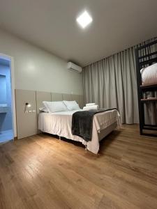 a bedroom with a bed and a wooden floor at Rio Jordao Hotel in Siderópolis