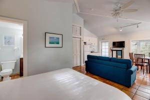 a living room with a blue couch and a kitchen at Osprey Suite - Southernmost Sanctuary in Key West