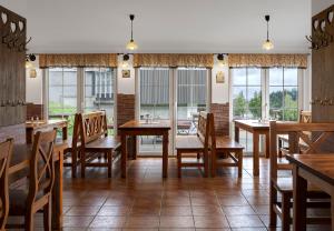 a restaurant with wooden tables and chairs and windows at Chata VIKTORKA, Černá hora in Janske Lazne