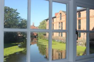 a window with a view of a river seen through it at ChocoLets - The Foss Suite in York
