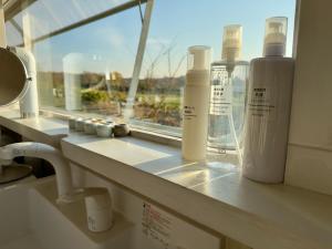 a window with bottles on a counter next to a sink at Silent Cabin -dog friendly villa- in Nakagoya