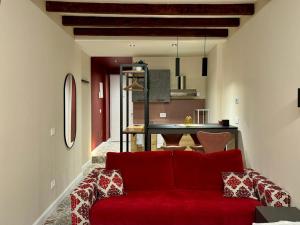 a living room with a red couch and a kitchen at Appartamento Frida in Brescia